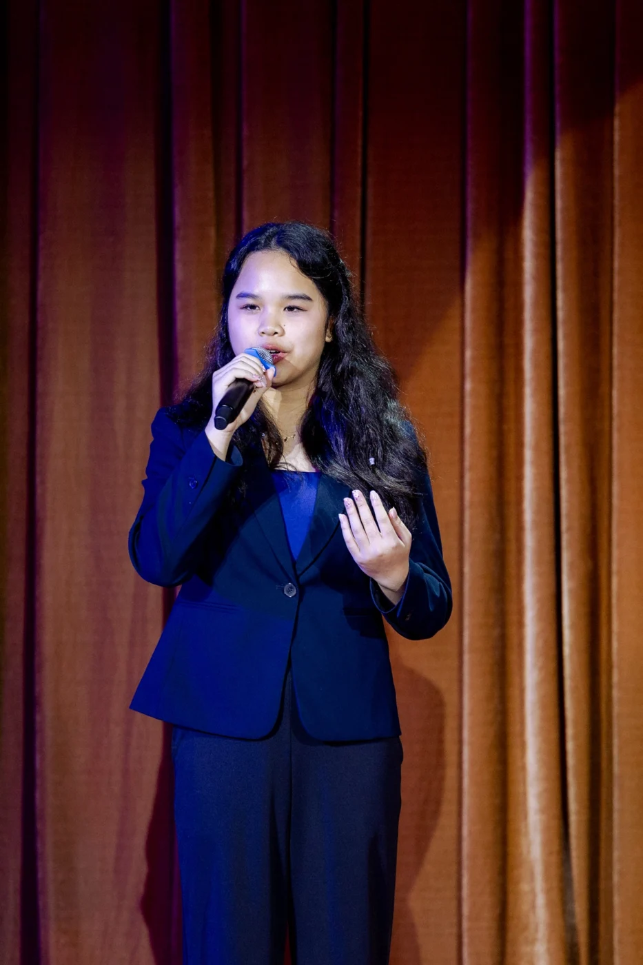 Speaking into a microphone on stage
